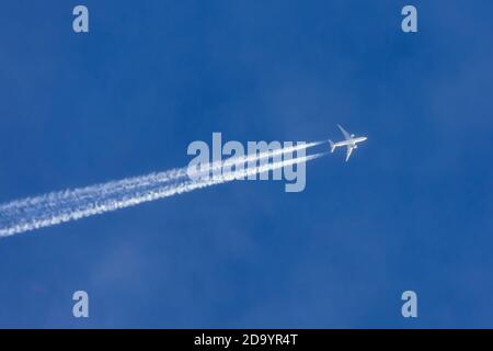 Gli aeroplani che lasciano la traccia controtaia si trasformano in un cielo blu chiaro Foto Stock