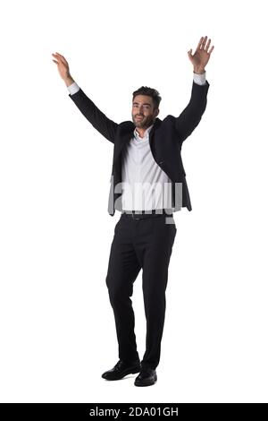 Ritratto a lunghezza intera di un giovane bel uomo d'affari in nero tuta con bracci rialzati in alto studio isolato su sfondo bianco Foto Stock