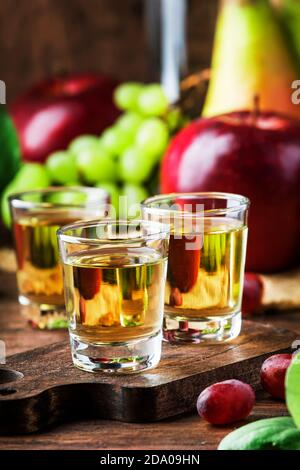 Rakija, raki o rakia - bevanda alcolica dura balcanica o brandy da frutta fermentata, tavolo di legno antico, vita still, spazio di copia Foto Stock