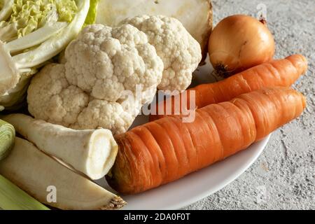 Primi piatti di carote, cavolfiore, radice di prezzemolo e altri ingredienti per preparare un brodo vegetale o una zuppa Foto Stock