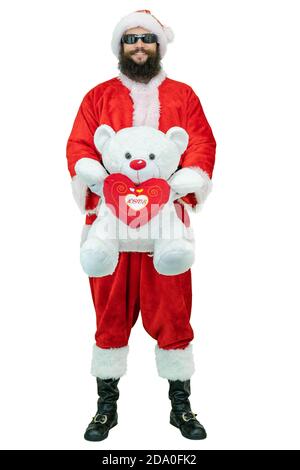 Santa con orsacchiotto. Il giovane arabo Babbo Natale con la barba nera tiene l'orso peloso su sfondo bianco. Natale in arrivo Foto Stock