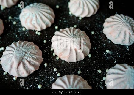 Marshmallow rosa su sfondo scuro. Marshmallow o zephyr, dolci e dolci fatti in casa, bianchi e rosa. La vista dall'alto Foto Stock