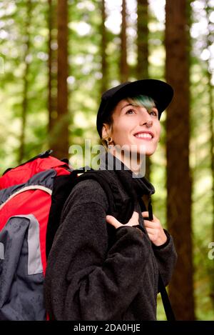 Contenuto turistico femminile con zaino in piedi in legno e godere Incredibile scenario di grandi alberi nel Monte Cabezon Monumento Naturale Di sequoie Foto Stock