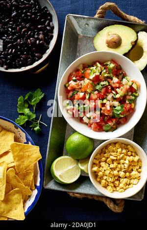 Ingredienti per cucinare i peperoncini - fagioli neri, patatine di tortilla, mais e salsa Foto Stock