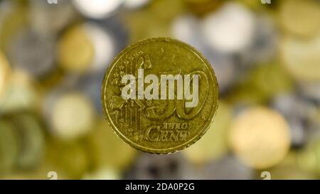 Un primo piano mostra una moneta da 50 centesimi di euro. Questo è denaro. Sfondo di denaro sfocato. Moneta sostituibile dell'eurozona del valore di 0.5 euro. La moneta è di Nordi Foto Stock