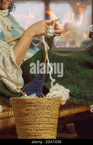 Vista laterale di una donna seduta su una sedia di rattan unione Foto Stock