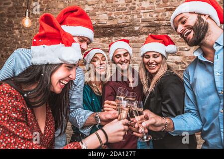 Buon Natale e felice anno nuovo! - giovani amici sorridenti multirazziali festeggiano la vacanza al bar - gruppi di giovani uomini d'affari stanno tostando Foto Stock