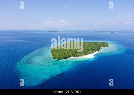 Seascape con una bella isola tropicale, vista aerea. Mahaba Isola, Filippine. Mare blu con le lagune turchesi. Estate viaggi e concetto di vacanza. Foto Stock