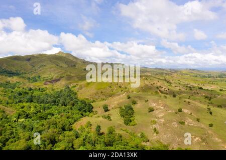 Colline con erba verde e blu del cielo con il bianco puffy nuvole. Bellissimo paesaggio dell isola di Luzon, vista aerea. Foto Stock