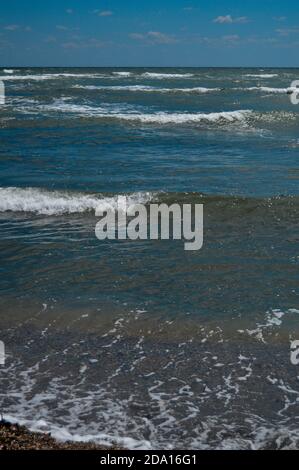 Closeup di onde di mare frose che scorrono verso la riva, scenografico paesaggio acquatico sullo sfondo Foto Stock