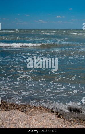 Closeup di onde di mare frose che scorrono verso la riva, scenografico paesaggio acquatico sullo sfondo Foto Stock