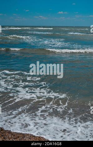 Closeup di onde di mare frose che scorrono verso la riva, scenografico paesaggio acquatico sullo sfondo Foto Stock