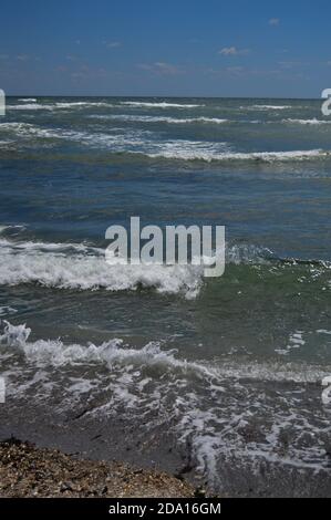 Closeup di onde di mare frose che scorrono verso la riva, scenografico paesaggio acquatico sullo sfondo Foto Stock