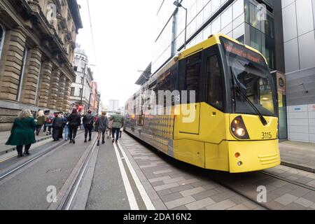 Manifestanti a manchester contro la passeggiata lockdown lungo le linee tramviarie accanto a un tram in esecuzione, 08-11-2020 Foto Stock