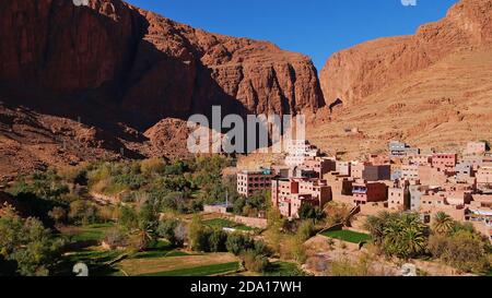 Piccolo villaggio berbero situato in una valle verde oasi con campi e palme vicino Tinghir, Marocco, nel sud delle montagne dell'Atlante. Foto Stock