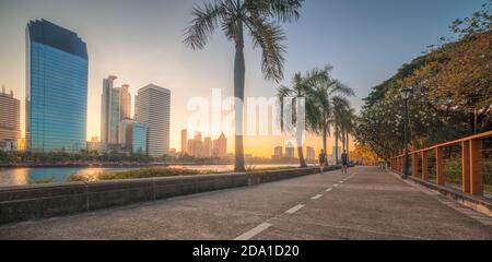 Pista da running di Nizza nel parco cittadino. Splendida vista del parco Benjakiti all'alba. Bella scena mattutina del Parco pubblico a Bangkok, Thailandia, Asia. Foto Stock