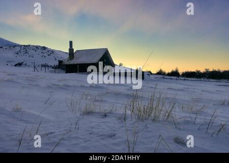 Rifugio in pietra innevata dell'Altopiano Galvarina nel Parco dell'Etna al tramonto, Sicilia Foto Stock