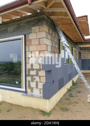 Isolamento termico con polistirene grafite sulla parete della casa in il cantiere Foto Stock