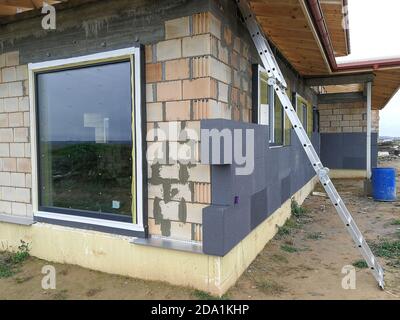 Isolamento termico con polistirene grafite sulla parete della casa in il cantiere Foto Stock