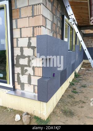 Isolamento termico con polistirene grafite sulla parete della casa in il cantiere Foto Stock