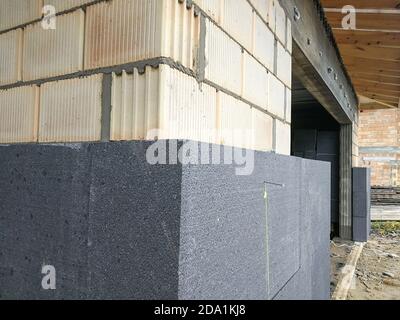 Isolamento termico con polistirene grafite sulla parete della casa in il cantiere Foto Stock