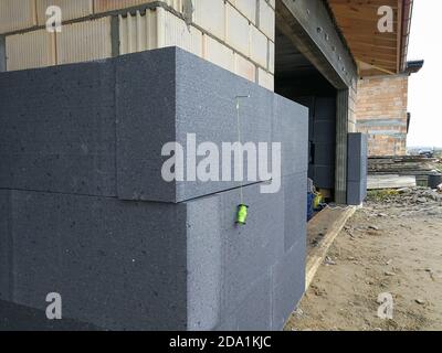 Isolamento termico con polistirene grafite sulla parete della casa in il cantiere Foto Stock