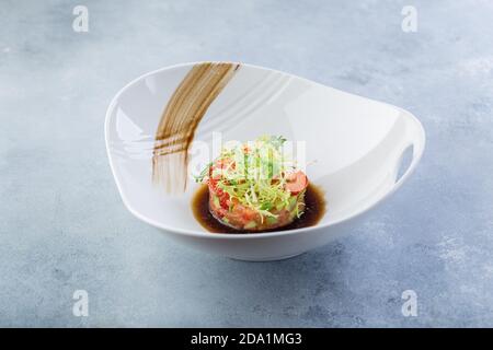 Tartare di pesce crudo preparato dallo chef. Presentazione originale. Foto Stock