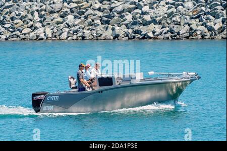 Mackay, Queensland, Australia - Ottobre 2019: Tre uomini in una piccola barca a velocità sulla loro strada per l'oceano per una giornata di pesca Foto Stock