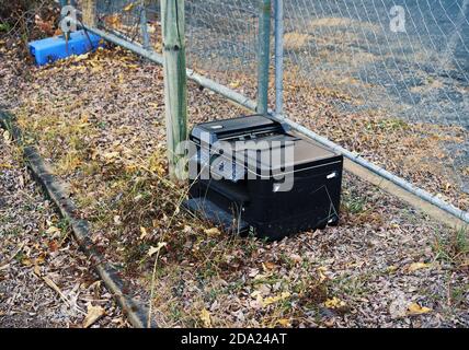 Mackay, Queensland, Australia - Novembre 2019: Una vecchia fotocopiatrice scartata abbandonata nelle erbacce e foglie morte di un ufficio di demolizione si Foto Stock