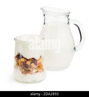 yogurt sano a strati con muesli e frutta con vasetto di latte su sfondo bianco Foto Stock