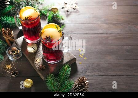 VIN brulé di Natale con spezie, mele e arance su tavola rustica in legno, spazio copia. Bevanda calda tradizionale per le vacanze di Natale e d'inverno Foto Stock