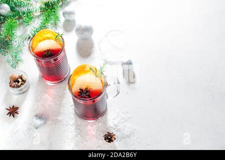 Natale VIN brulé rosso con spezie, mele e arance su sfondo bianco, spazio copia. Bevanda calda tradizionale per le vacanze di Natale e d'inverno. Foto Stock