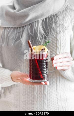 Donna che tiene la tazza di VIN brulé caldo, copy space. Mani femminili con tazza di bevanda calda invernale stagionale. Bevanda di Natale fatta in casa, piccante VIN brulé rosso Foto Stock