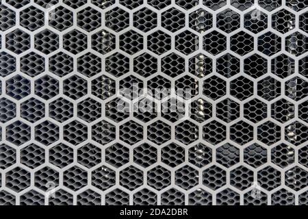 Fondo metallico con perforazione dei fori esagonali, rete di cerchi Foto Stock