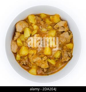 Cibo naturale cucinato a casa. Ragù di patate gustose e gufo. Un piatto di gufo di manzo stufato e patate su fondo bianco isolato. Foto Stock