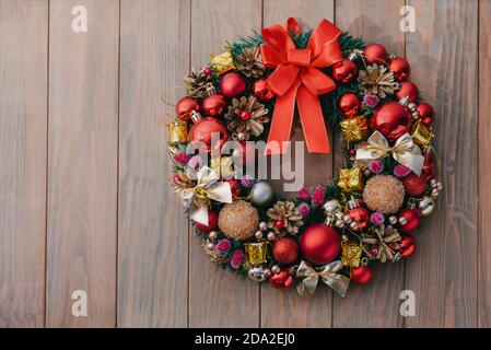 Corona di Natale su sfondo di legno. Decorazioni natalizie fatte a mano Foto Stock