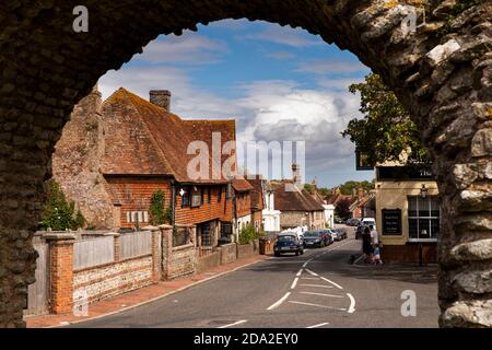 Regno Unito, Inghilterra, East Sussex, Pevensey, Castle Road e Old Mint House attraverso l'arco nel muro romano Foto Stock