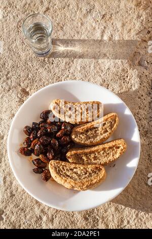 Cretese, olive e tsikoudia (raki), un delizioso pasto snack come spesso offerto a Creta. Tutti e tre i prodotti sono di tipica cucina cretese. Foto Stock