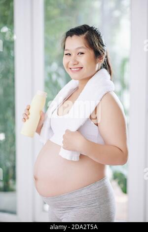 Donna in gravidanza sportiva felice Foto Stock