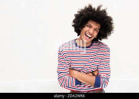 Ritratto fresco giovane arabo ridendo con le braccia incrociate sfondo bianco isolato Foto Stock