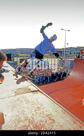 Il pattinatore professionista Tony Hawk macina il coping sull'enorme rampa di halfpipe accanto al vecchio stadio Morfa in n Swansea n 1990. Foto Stock