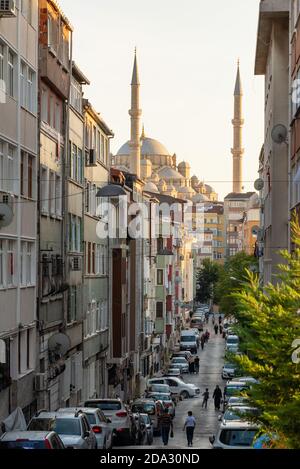 Strada nel quartiere residenziale di Istanbul con Fatih Camii moschea sullo sfondo, Turchia Foto Stock
