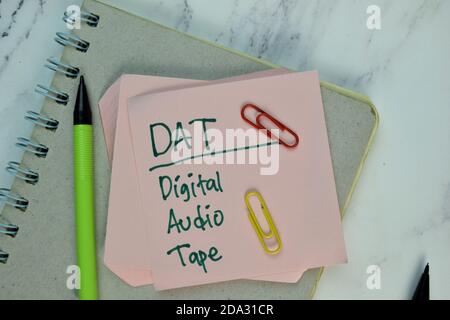 DAT - nastro audio digitale scrivibile su nota adesiva isolato su tavolo di legno. Foto Stock