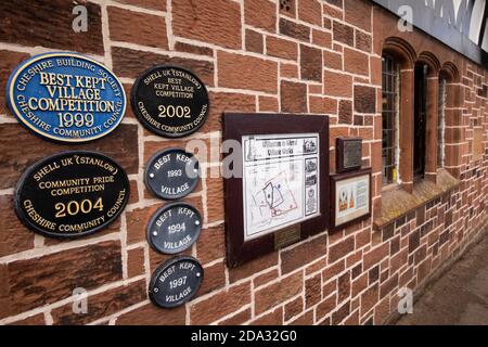 Regno Unito, Inghilterra, Cheshire, Willaston, Green, le targhe del villaggio meglio conservate sulla parete del Village Hall Foto Stock