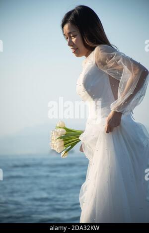 Ragazza asiatica vestita come sposa scattando foto a Sai WAN Molo di carico (chiamato anche molo di Instagram) a Hong Kong Foto Stock