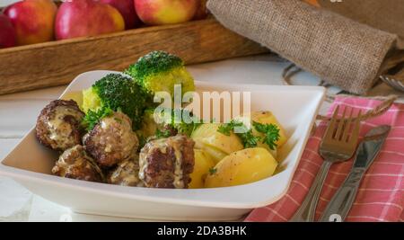 polpette con salsa alla crema, broccoli e potatos su un piatto Foto Stock