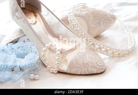 Primo piano delle scarpe e dei gioielli della sposa. Foto Stock