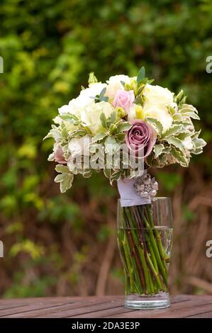 Bouquet nuziale in un bicchiere d'acqua. Foto Stock