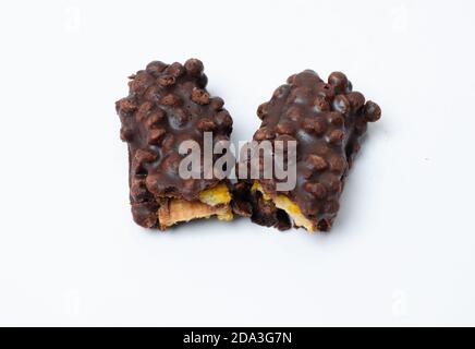 Pezzi rotti di noci e barretta di cioccolato al latte isolati sopra sfondo bianco Foto Stock