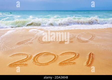 2021 scritto sulla sabbia di una spiaggia, viaggio 2021 nuovo anno di concetto e biglietto d'auguri Foto Stock